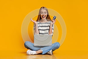 Excited girl using laptop and credit card for purchasing online