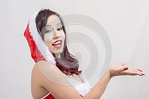 Excited Girl wearing Santa Claus costume presenting your product