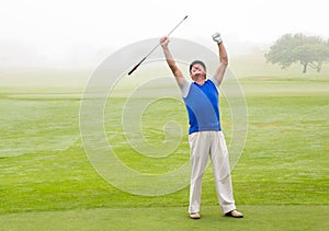 Excited golfer cheering on putting green