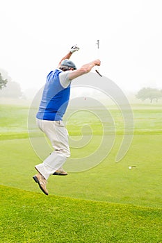 Excited golfer jumping up