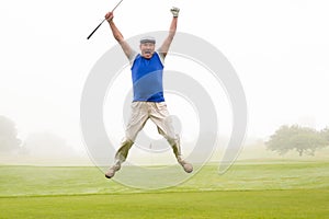 Excited golfer jumping up and smiling at camera