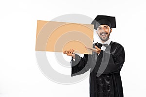 Excited graduate male students wearing toga holding blank space carton