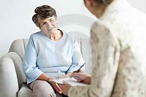 Excited grandmother talking to a psychologist about positive lif
