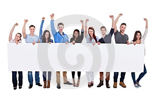 Excited group of diverse people holding banner