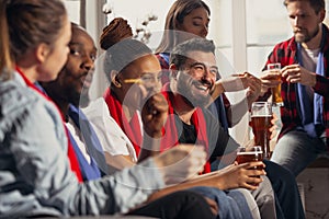 Excited group of people watching football, sport match at home