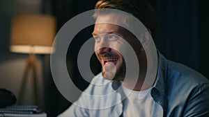 Excited guy laughing enjoying movie closeup. Freelancer watching comedy at night