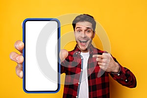 Excited guy pointing at black empty smartphone screen