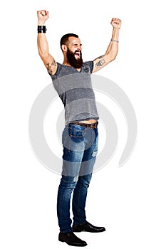 Excited handsome Tattooed bearded man with arms raised