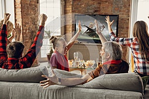 Excited, happy big family team watch sport match together on the couch at home photo