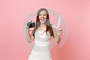 Excited happy bride woman in wedding dress holding retro vintage photo camera and check mark, choosing staff