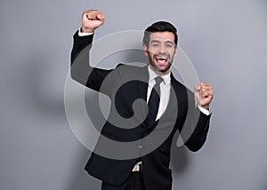 Excited and happy businessman dressed in black formal suit. Fervent