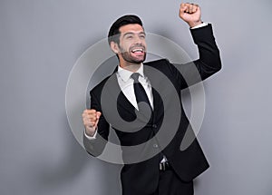 Excited and happy businessman dressed in black formal suit. Fervent