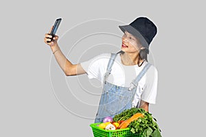 Excited and Happy Farmer Girl with Fruits and vegetables on a mobile phone