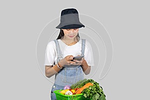 Excited and Happy Farmer Girl with Fruits and vegetables on a mobile phone