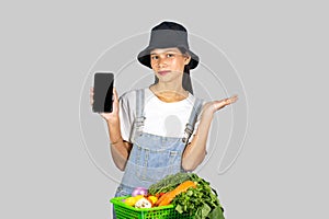 Excited and Happy Farmer Girl with Fruits and vegetables on a mobile phone