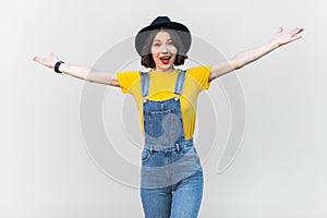 Excited happy hipster woman spreads her arms, showing welcome gesture, inviting.