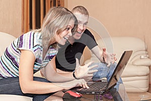 Excited and happy man and woman looking at screen of laptop, emotion during playing games or e-commerce or gambling