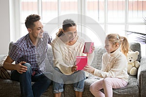 Excited happy mother opening gift box with present from daughter