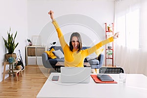 Excited happy pretty young woman celebrating success looking at laptop screen