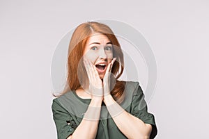 Excited happy red-haired woman on white background