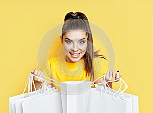 Excited happy woman holding shopping bags in hands and looking her purchase