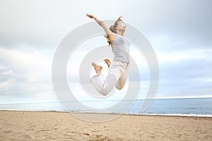 Excited happy woman jumping on the beach