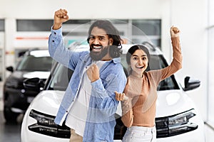 Excited hindu couple celebrating a new car purchase