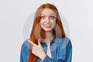 Excited and impressed, curious thrilled smiling redhead girl with long foxy, ginger hair and blue eyes, stare amused