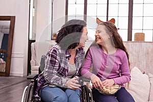 Excited incapacitated woman and girl enjoying comedy