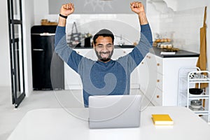 Excited Indian bearded male entrepreneur showing triumph gesture
