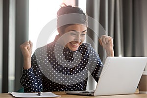 Excited indian employee receiving good news at office