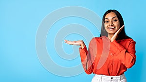 Excited Indian Lady Showing Space Gesturing With Hand, Blue Background