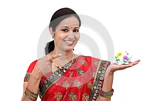 Excited Indian woman holding a piggy bank