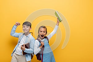 Excited interracial schoolkids holding books 