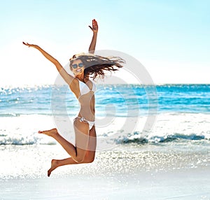 Excited, jump and portrait of woman at beach for summer adventure, energy and travel on holiday. Happy, tourist and