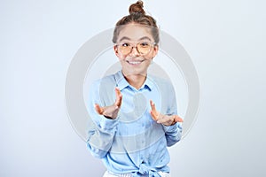 Excited kazakh asian girl clasped her hands opened mouth in surprise and bulged eyes against white background, isolated. Portrait