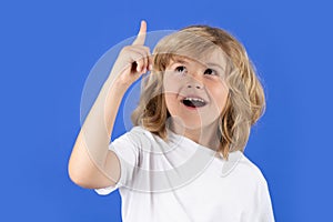 Excited kid boy have idea on blue isolated background. Surprised face, amazed emotions of child. Portrait of school boy