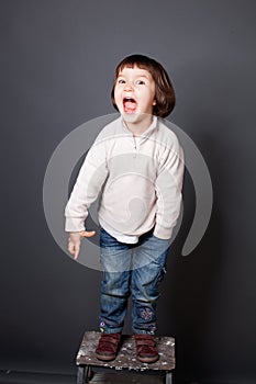 Excited kid laughing, having fun, expressing natural energies, real life