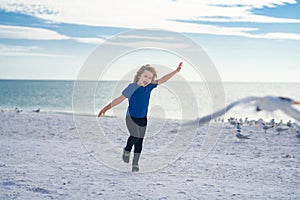 Excited kid running on beach. Little kid boy having fun on Miami beach. Happy cute child running near ocean hunting