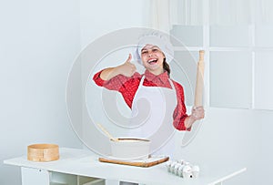 excited kid show thumb up in kitchen, success