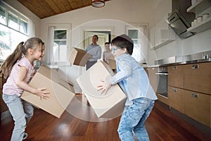 Excited kids having fun bringing in boxes to new house