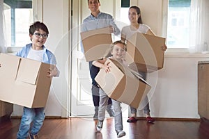 Excited kids running carrying boxes moving to new house