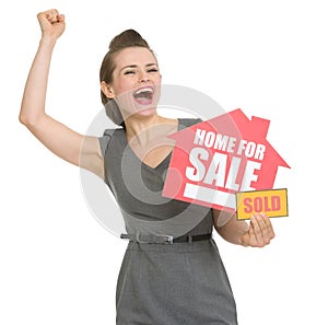 Excited landlord with home for sale sold sign