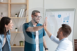 Excited leader in glasses giving high five to happy coworker.