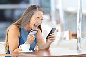 Excited on line buyer paying with credit card photo