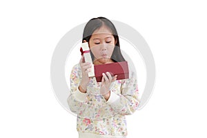 Excited little asian kid girl while open gift box on white background. Happy new year and Merry christmas concept