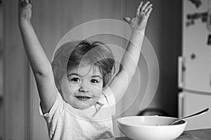 Excited little boy - ecology Food concept. Happy child have a breakfast. Portrait of sweet little laughing baby boy with