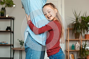 Excited little daughter embracing her pregnant mom, cute girl touching expecting mother tummy and smiling