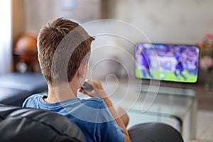 Excited little kid watching soccer match in TV