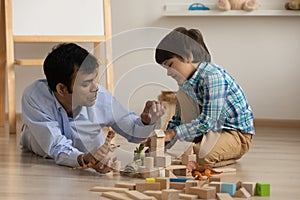 Excited little son and loving indian dad play toys together